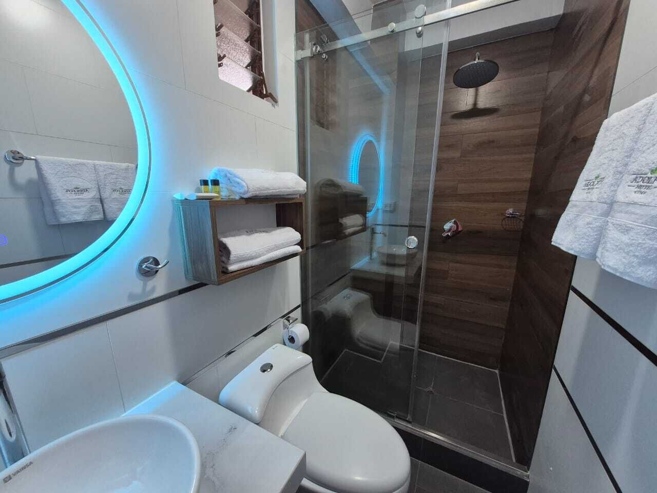 A modern bathroom with a toilet, sink, and glass-enclosed shower.