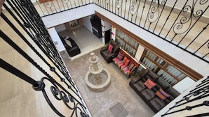 A spacious lobby with a central fountain, a staircase with ornate railings, and a seating area with a sofa and cushions. - Adolfos Hotel Cusco (Cusco)