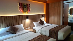 A hotel room with two beds, a wooden headboard, a wall-mounted light, and a mirror. - Adolfos Hotel Cusco (Cusco)