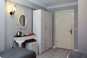 A bedroom with a bed, a dresser, a mirror, and a door. - Nova City Hotel (Istanbul)