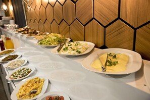 A buffet table with various dishes and a wooden wall with a geometric pattern. - Nova City Hotel (Istanbul)
