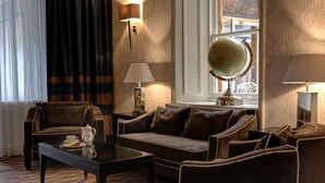 Ein Hotelzimmer mit einer Couch, zwei Sesseln, einem Couchtisch und zwei Lampen.