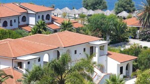 Una proprietà costiera con diversi edifici, tetti in tegole rosse e vista sul mare.
