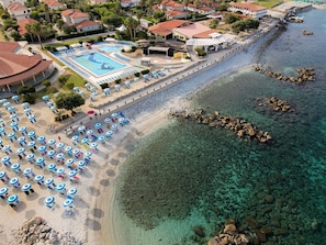 A coastal resort with a swimming pool, beach umbrellas, and clear waters. - Villaggio Torre Ruffa Robinson (Ricadi)