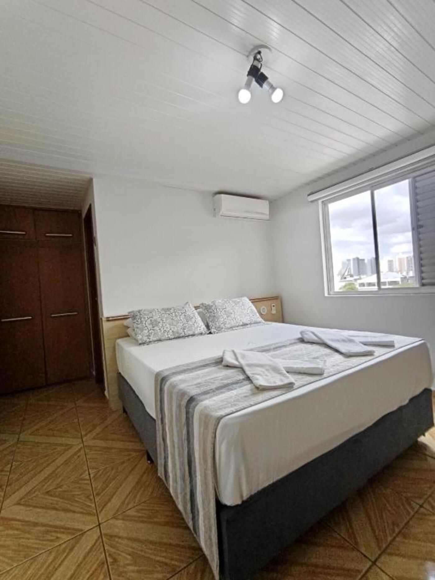 Quarto com cama, janela e porta.
