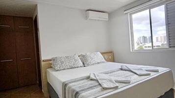 Quarto com cama, janela e porta.