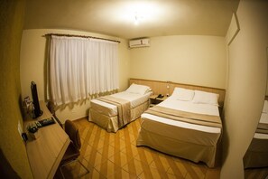 A hotel room with two beds, a desk with a computer, a telephone, and a window with curtains. - Harbor Self Cidade Verde (Maringá)