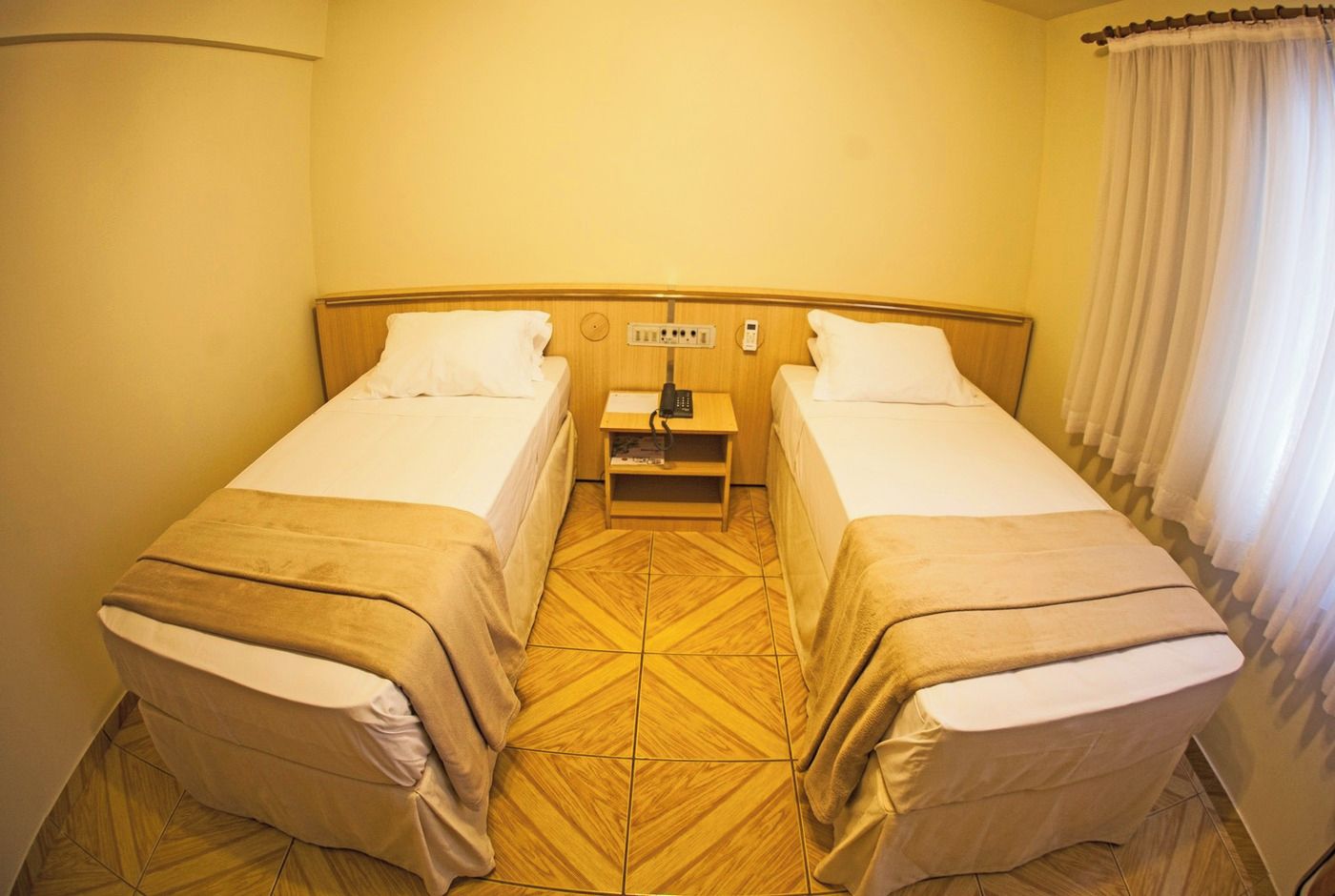 A double room with two beds, a small bedside table, and a nightstand.