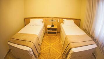 A double room with two beds, a small bedside table, and a nightstand.