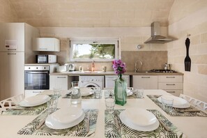 Una cocina compacta con comedor para dos personas. Incluye microondas, hervidor, pileta y estufa.