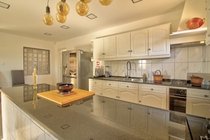 A modern kitchen with white cabinets, a marble backsplash, and stainless steel appliances. - Villa 'Amadeus' with Private Pool, Wi-Fi and Air Conditioning (Moncarapacho)