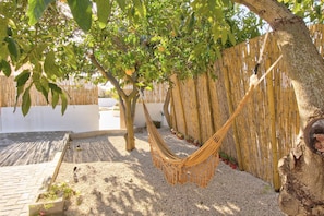 A hammock under a tree, gravel ground, and a bamboo fence. - Villa 'Amadeus' with Private Pool, Wi-Fi and Air Conditioning (Moncarapacho)