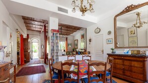 A dining area with a wooden table, chairs, and a chandelier. - Les Citronniers - Bibliothèque Guest Room with Shared Terrace, Wi-Fi & Air Conditioning (Marseille)