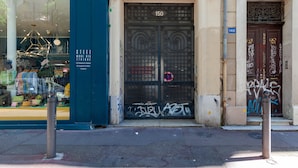 A storefront with a metal gate, a number '150' above the door, and a window displaying various items. - Guest Room "Les Citronniers - Chapeaux" with Shared Terrace, Wi-Fi and Air Conditioning (Marseille)