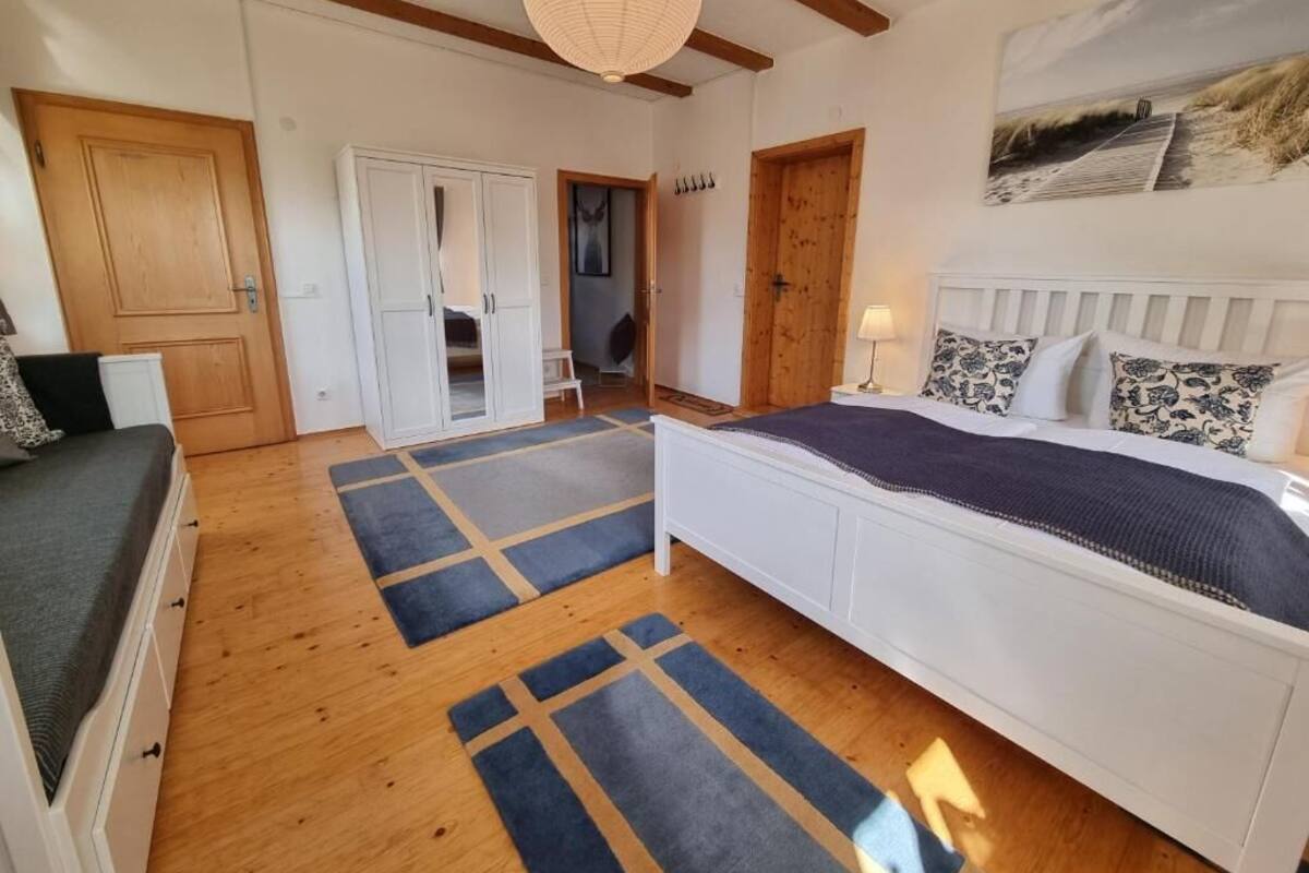 A bedroom with a bed, a wardrobe, a door, and a hallway.