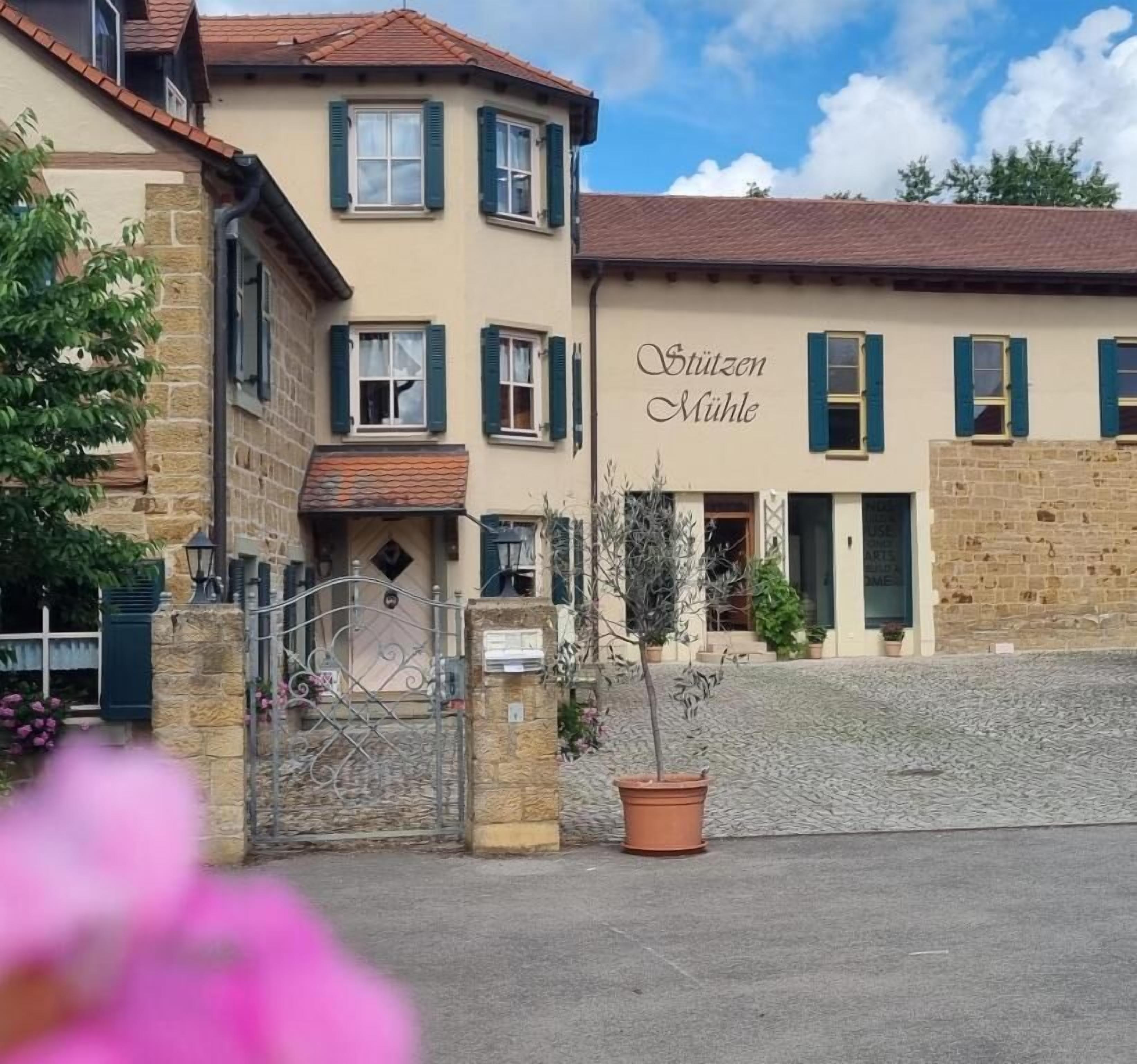 A building with a sign reading 'Stützen Mühle' and a cobblestone courtyard.