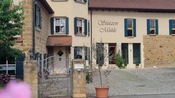 A building with a sign reading 'Stützen Mühle' and a cobblestone courtyard.