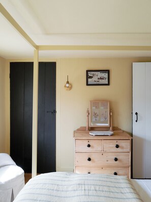 A bedroom with a bed, a dresser with drawers, a framed picture on the wall, and a door. - NEW Design Forward Retreat Near New Hope Stockton (Stockton)