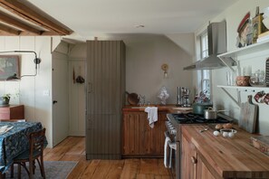 A kitchen with wooden cabinets, a stove, and various kitchen utensils. - NEW Design Forward Retreat Near New Hope Stockton (Stockton)