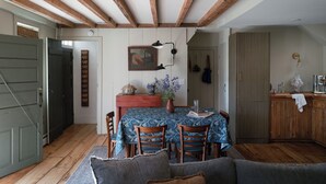 Zona pranzo con tavolo, sedie e un quadro appeso al muro.