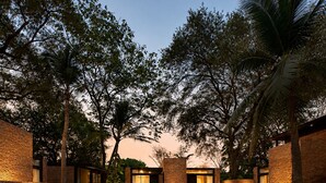 A swimming pool with surrounding brick walls and trees. - Makham Villa River Kwai (Kanchanaburi)
