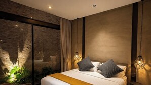 A modern bedroom with a large bed, a desk, and a view through a large window. - Makham Villa River Kwai (Kanchanaburi)
