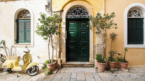 A yellow building with a green door, potted plants, and a yellow scooter. - Dei Vecchi Casa by Corfuescapes  (Corfu)