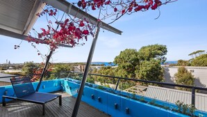 En balkon med havudsigt, en pool og et bord.