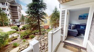 A residential building with a porch, a welcome mat, and a view of a neighboring building.
