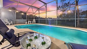 A poolside area with lounge chairs, a pool, and a view of the sky. - Stylish 3BR, Pool, Golf Views, Disney and Legoland (Haines City)