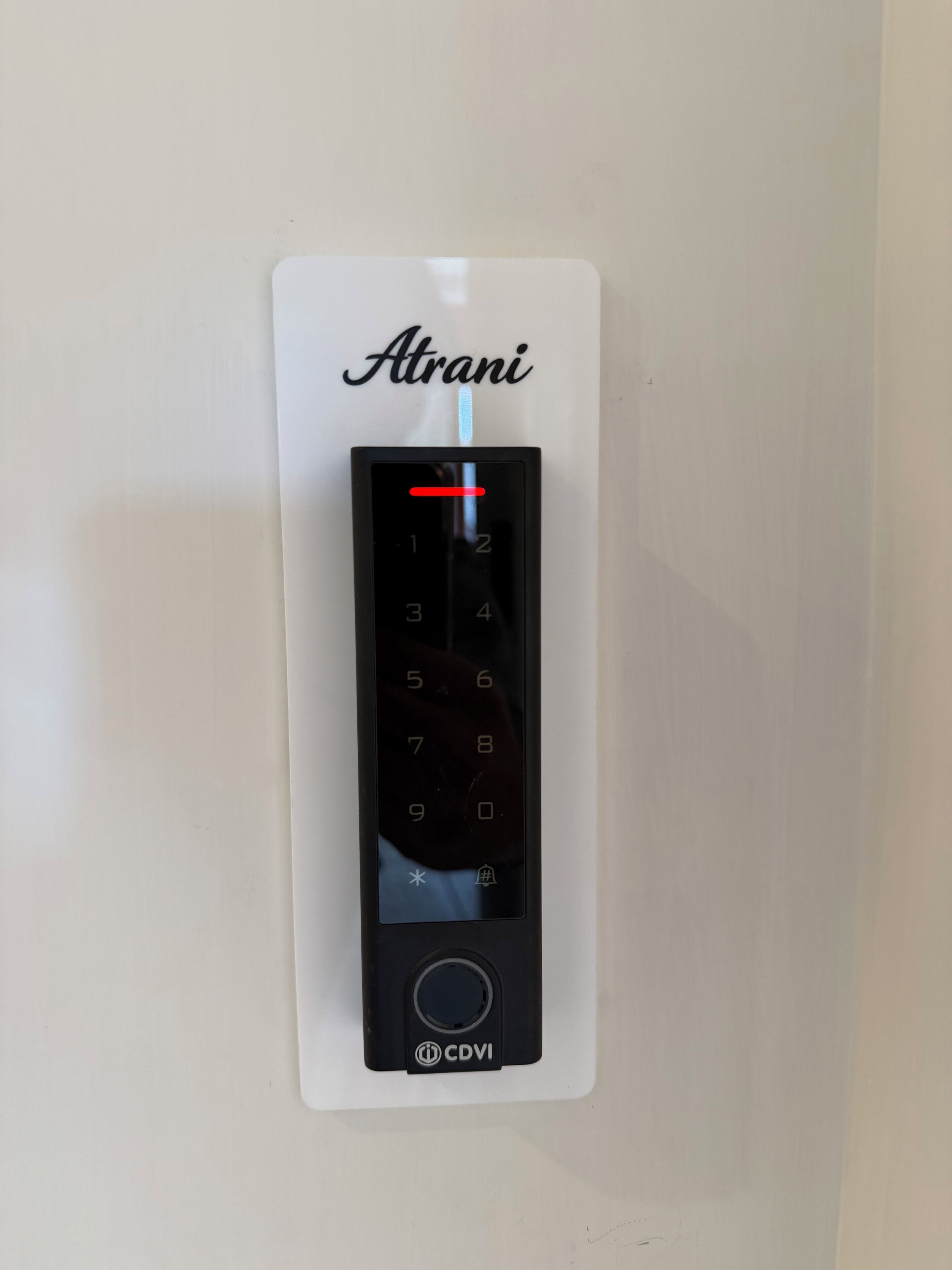 Un ascensor empotrado en la pared con un teclado digital y el nombre de marca 'Atrani' en la parte superior.
