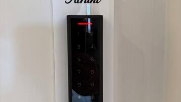 Un ascensor empotrado en la pared con un teclado digital y el nombre de marca 'Atrani' en la parte superior.