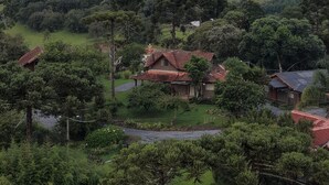 Un paysage rural avec des maisons entourées de verdure et des collines en arrière-plan.