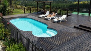 Une piscine avec des chaises longues et une vue sur les montagnes.