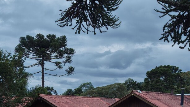 Un bâtiment en bois avec un toit rouge, un espace extérieur couvert avec des sièges et une terrasse en bois.