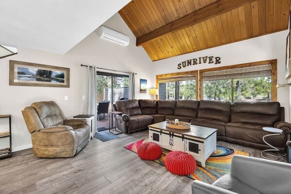 A spacious living room with a large brown leather sofa, a recliner, and a coffee table. - Location! SHARC is a skip away! (Sunriver)
