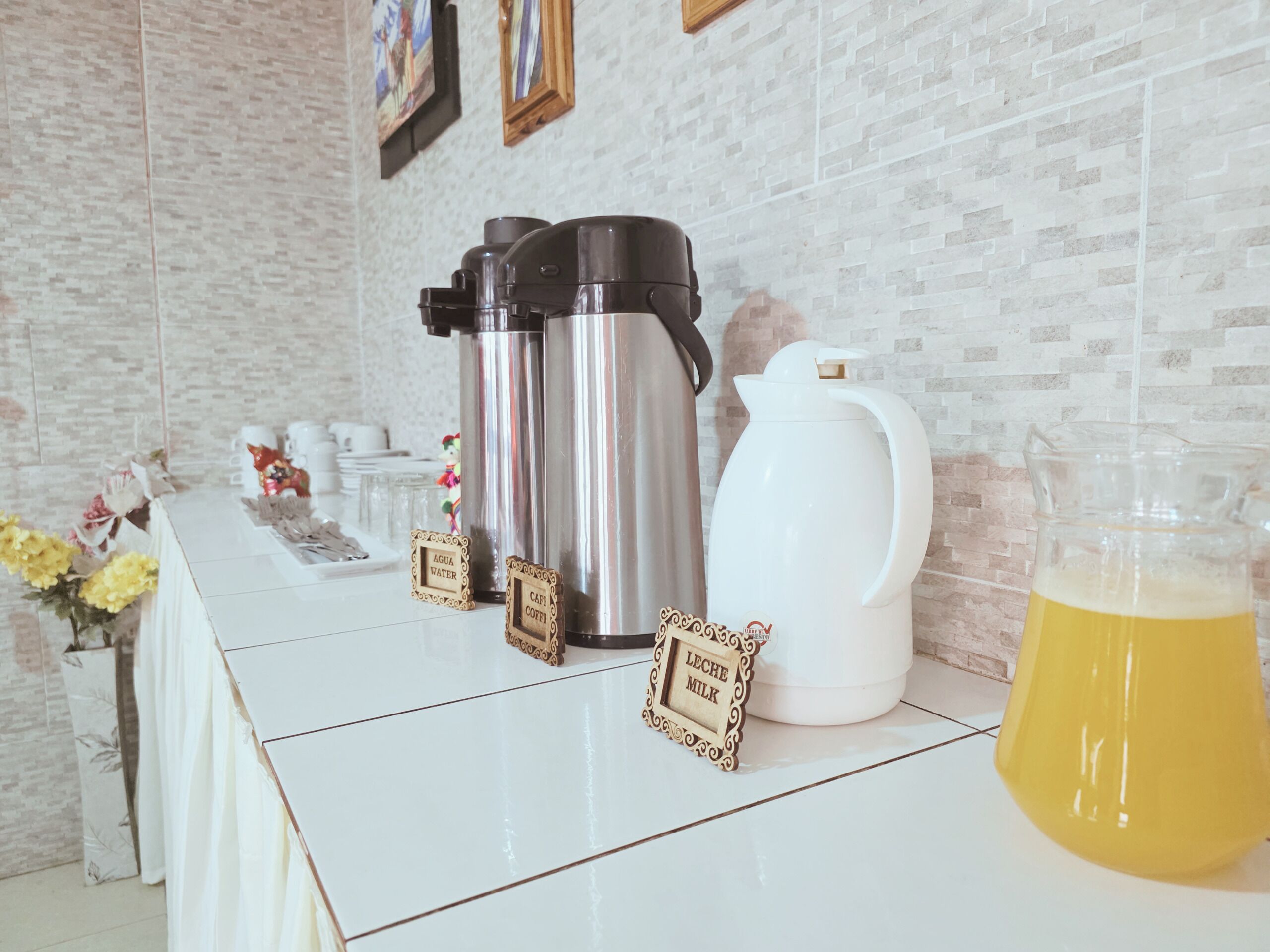 Een koffiehoek met een koffiezetapparaat, melkkan en een kan koffie.