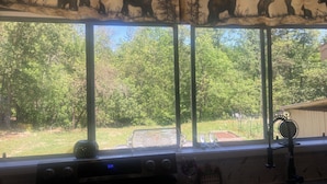 Una cocina con ventana, un reloj y un florero en el alféizar.