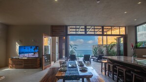 Un espace repas avec vue sur l’océan, un téléviseur et un coin bar.