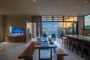 Ein Essbereich mit Meerblick, einem Fernseher und einer Bar.