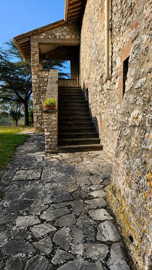 A stone staircase leading to a wooden door, surrounded by stone walls and a stone-paved path. - Caserinzio Farmhouse - Girasole: Panoramic View with Pool (avigliano umbro)