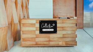 A wooden reception desk with a sign that reads 'Collection Company-Serviced.' - Super Deluxe Roomhotel Navjivan (Himatnagar)
