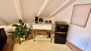 A compact kitchenette with a small fridge, a coffee maker, and a plant. - Rooftop Lounge Studio Apartment directly at the University Hospital Homburg (Homburg)