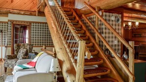 A wooden interior with a staircase, a sofa, and a lamp. - The Log House - Wellington - with Fast Wifi (Wellington)