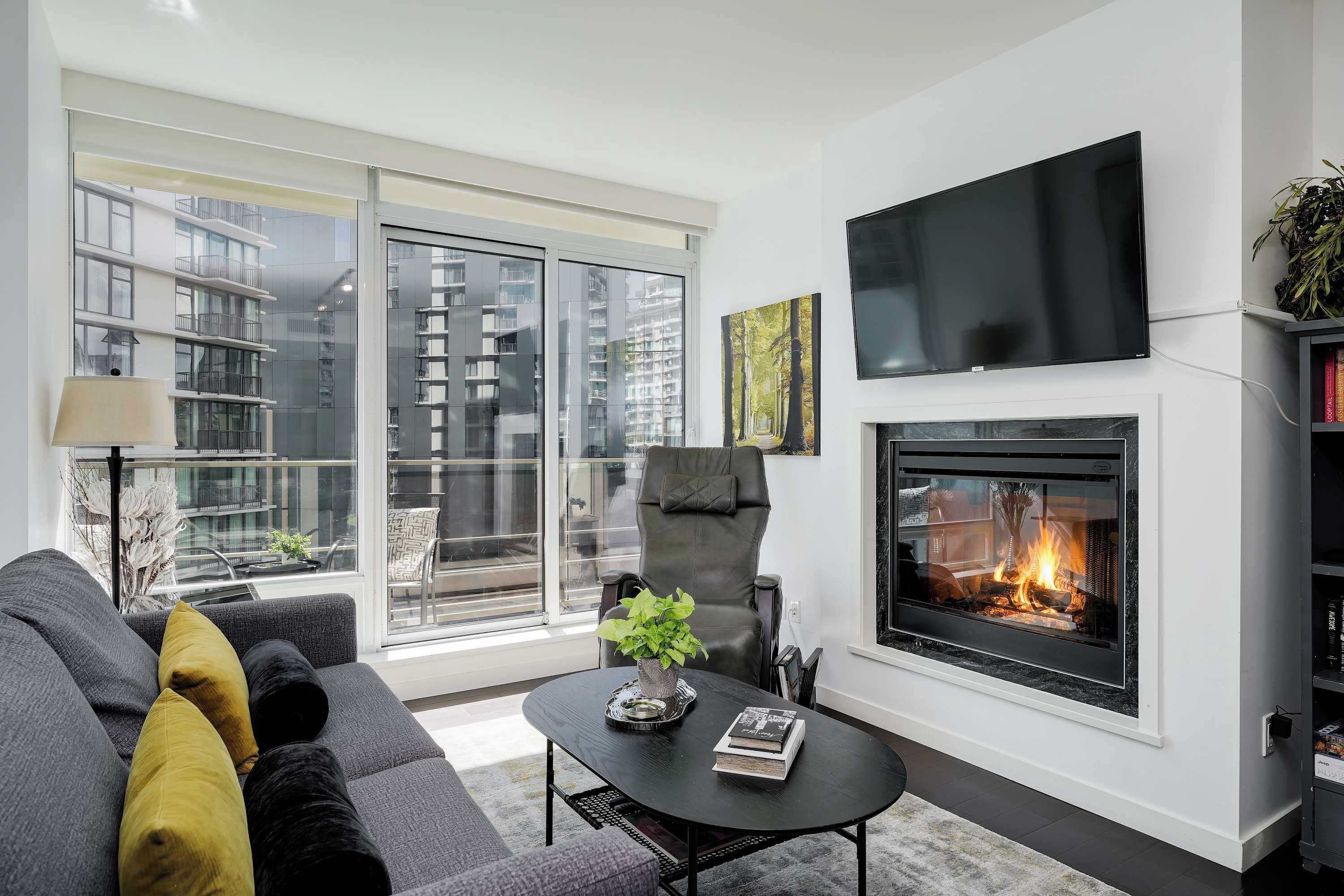 A modern living room with a fireplace, a sofa, a coffee table, and a television.