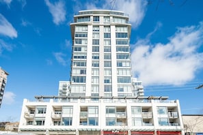 Un edificio de varios pisos con una torre central, balcones y una entrada a nivel de calle.
