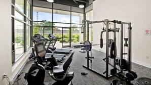 Ett gym med löpband, en viktbänk och en ställning för knäböj.