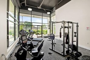 Un gimnasio con cintas de correr, una banca de pesas y una estructura para sentadillas.