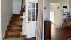 Un escalier avec des marches en bois et une porte blanche dotée de panneaux de verre.