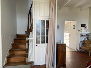 Una escalera con peldaños de madera y una puerta blanca con paneles de vidrio.